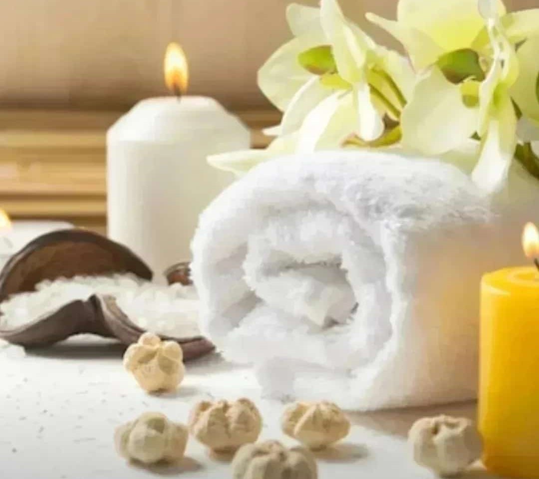 Mumlar, havlu ve orkidelerle aromaterapi ortamı